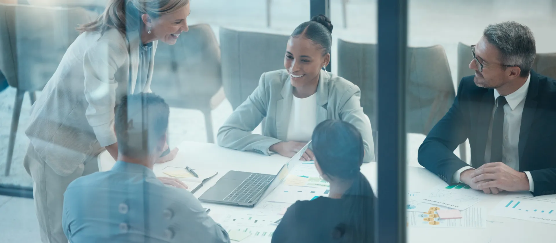 Team working together on project documents in a modern meeting room.