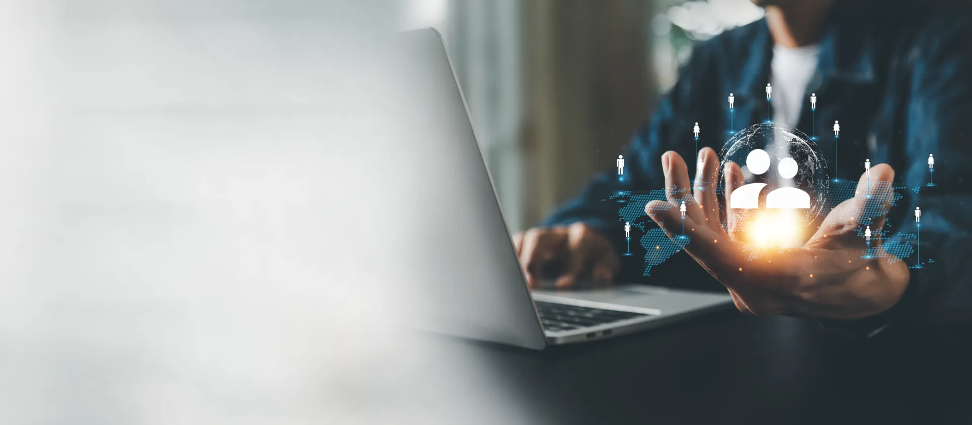 Laptop and hand with networked world map as a symbol of global cooperation.
