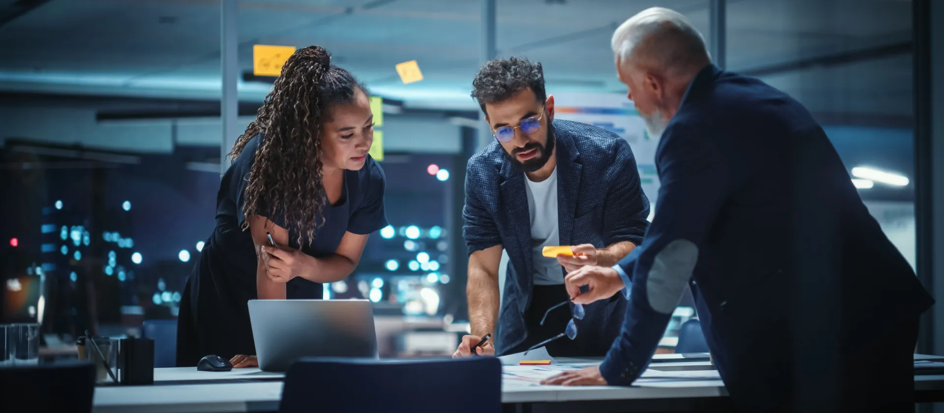 Team discussing project documents and optimization approaches in an office setting – representing Organization, Performance & Change with a focus on process mining, change management and training.